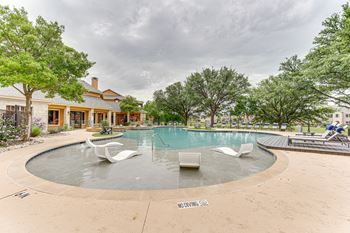 Swimming pool with tanning ledge and white loungers